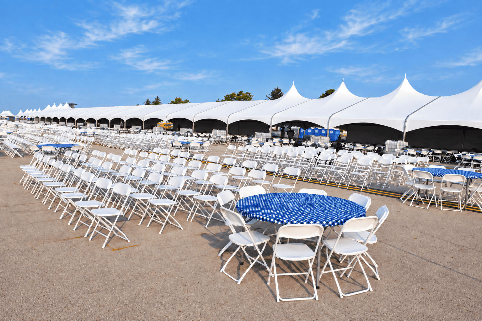 Mustang Club Mustang Club seating area with rows of white chairs, reserved tables, and large canopy tents along the flightline.